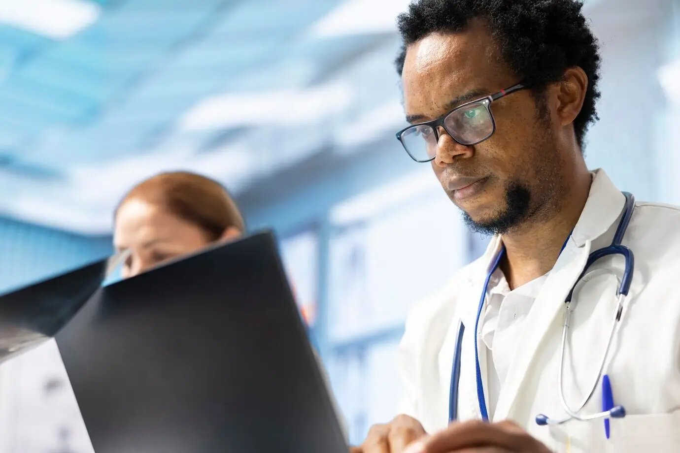 Разнообразная команда медиков на совещании изучает результаты рентгенографии и медицинские данные.