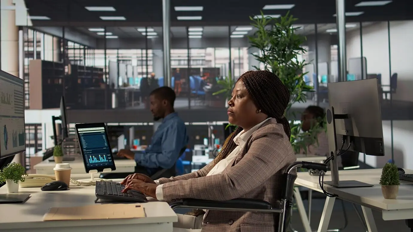 Афроамериканский сотрудник с инвалидностью работает над финансовой стратегией.